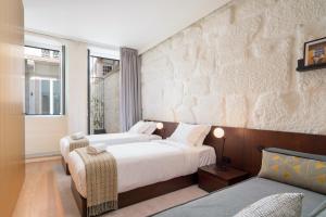 波尔图d'ALMA Boutique Hotel的一间带两张床和一张沙发的卧室