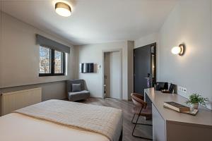 雅典雅典美宿酒店的一间卧室配有一张床、一张桌子和一把椅子