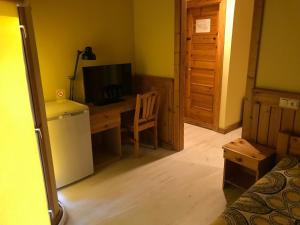 KarjamaaPuhkekeskus SUVI的客房设有书桌、电视和冰箱。