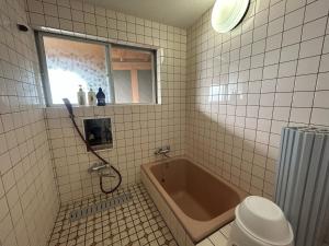 TogiStella in Noto的带浴缸、卫生间和窗户的浴室