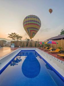 万荣Vang Vieng Chill House的飞过游泳池的热气球