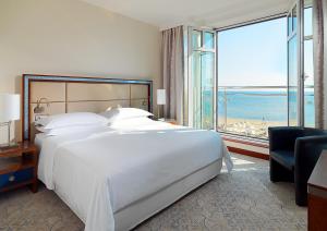 索波特索波特喜来登酒店的卧室设有一张白色大床和大窗户