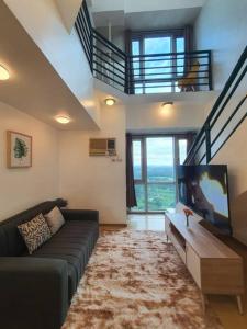 马尼拉BGC Loft in Avant, stunning golf view!的带沙发和平面电视的客厅
