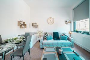 巴恩斯利Cozy 1-Bedroom Apartment in the Heart of Barnsley Town Centre的客厅配有蓝色的沙发和桌子