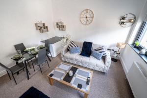 巴恩斯利Cozy 1-Bedroom Apartment in the Heart of Barnsley Town Centre的客厅配有沙发和桌子