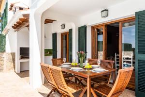 费雷列斯Villa Vista Alegre - Cala Galdana的一间带木桌和椅子的用餐室