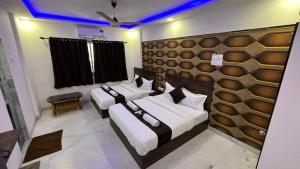 孟买Hotel Plaza Rooms - Prabhadevi Dadar的一间设有三张床的客房,房间拥有蓝色的灯光