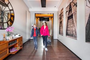 汉堡Hotel Volksschule的两位女士走下走廊,墙上挂着艺术品