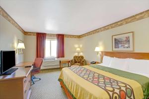 盐湖城Royal Inn Airport Salt Lake City的配有一张床和一张书桌的酒店客房