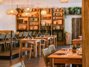 阿维尼翁南阿维农宜必思尚品酒店的一间带木桌、椅子和架子的餐厅