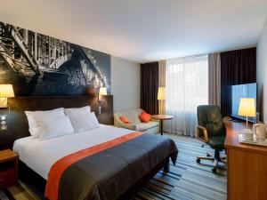 华沙华沙中心美居酒店的配有一张床和一张书桌的酒店客房