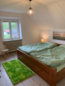 HuglfingFerienwohnung 2 in Huglfing im Herzen vom 5 Seen Land Oberbayern的一间卧室配有一张带绿色床单和绿色地毯的床。