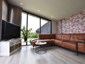 HaulerwijkSerene chalet in Haulerwijk with enclosed garden and views的带沙发和电视的客厅