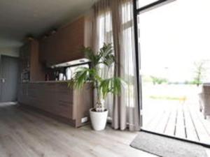 HaulerwijkDetached chalet in Friesland with fenced garden的客厅配有盆栽植物和大窗户