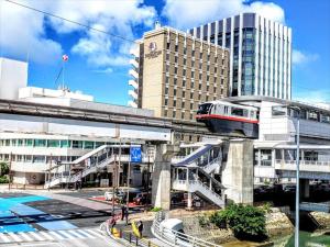那霸かりゆしコンドミニアムリゾート那覇 グランステイ旭橋駅前的一座有建筑物的城市桥梁上的火车