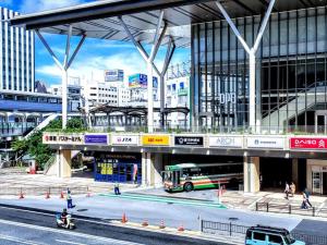 那霸かりゆしコンドミニアムリゾート那覇 グランステイ旭橋駅前的城市里一辆公共汽车在桥下行驶