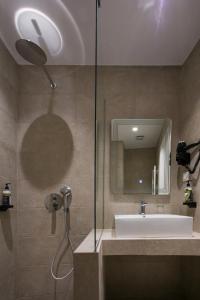 塞萨洛尼基White City Stay的一间带水槽和玻璃淋浴的浴室