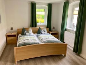 卡劳特格瑞斯赫Ferienwohnung "Am Kirchsteig"的一间卧室配有一张带绿色窗帘的大床