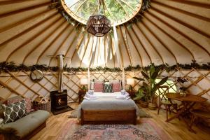 里彭Yurtshire Eavestone Lake - Birch Yurt的蒙古包内一间卧室,配有一张床和一张沙发