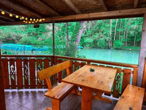 卡姆基亚“River Romance” Villa的木桌和长凳,在门廊上享有河景