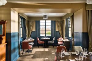 汤格唐古酒店的餐厅设有桌椅和窗户。