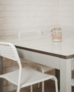 塔兰托迪莫拉马里尤住宿加早餐旅馆的前面设有白色的桌子和白色的椅子