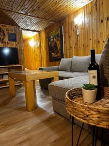 卡姆基亚“River Romance” Villa的客厅配有沙发和一张桌子及一瓶葡萄酒