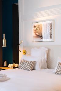 昂热Hôtel D'Anjou的卧室配有一张白色床,墙上挂着一幅画
