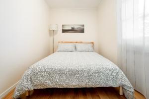 皮恩扎Il Nido的白色卧室,配有带被子的床
