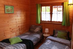 达布基Oaza Dąbek的小木屋设有两张床和窗户