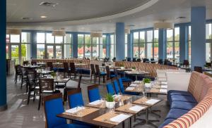 赖因斯贝格Precise Resort Hafendorf Rheinsberg的餐厅设有桌椅和窗户。