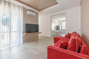 吉诺萨滨海Appartamento Vitalba by BarbarHouse的客厅配有红色沙发和电视