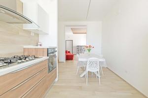 吉诺萨滨海Appartamento Vitalba by BarbarHouse的厨房配有桌子和桌椅