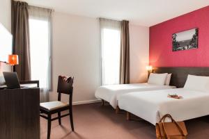 马赛马赛圣查尔斯阿德吉奥阿克瑟斯公寓式酒店的酒店客房,配有两张床和椅子