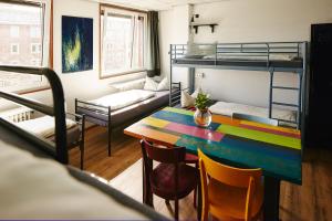 明斯特Sleep Station Hostel的小房间设有桌子和双层床