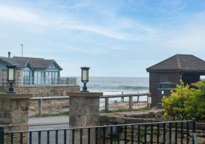 桑森德Clematis Cottage的享有海滩美景,设有房屋和大海