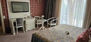 基希讷乌Savoy Hotel的酒店客房带一张床、一张桌子和椅子