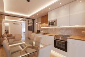 马德里Silva 20的厨房配有白色橱柜和桌椅