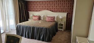 基希讷乌Savoy Hotel的一间卧室配有一张带红色壁纸的大床