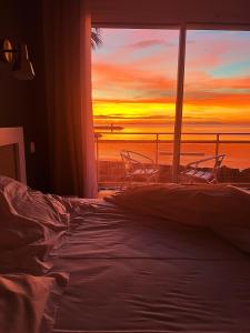 耶尔彭迪艾尔酒店的一间卧室设有一张床和一个享有日落美景的窗户