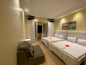 杉祖Lux Suites Shanzu Beachfront Apartments的一间卧室配有两张床和椅子