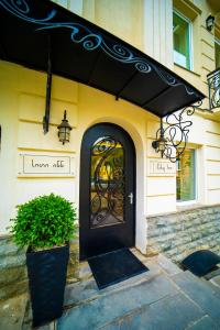 第比利斯City Inn Tbilisi的前面有植物的建筑物上的黑色门