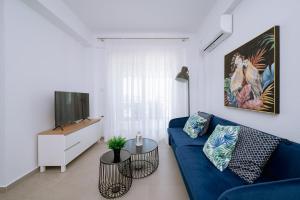 奥弗里安Danai & Palm Residential Complexes的客厅配有蓝色的沙发和电视