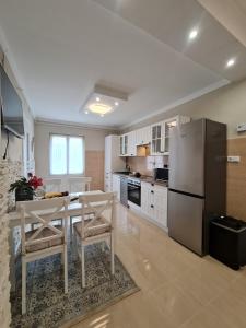久洛Belvárosi BástyaVár Apartman的厨房配有桌子和不锈钢冰箱。