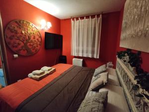 Collado MedianoApartahotel Rural CollaRubio Luxury的红色卧室,配有带毛巾的床