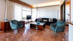 马塔罗Catalunya Casas Seafront bliss for 16 people 40km to Barcelona!的客厅配有两把椅子和一张沙发