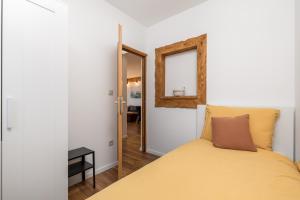 VrataApartman Roko的一间卧室配有黄色的床和镜子