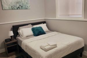 萨斯卡通Exquisite Cozy Suite/full amenities in Kensington的床上有蓝色枕头