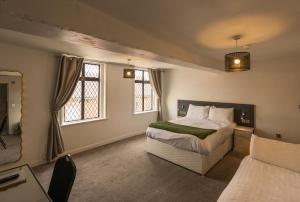 尤托克西特The White Hart Hotel的一间卧室设有一张床和两个窗户。