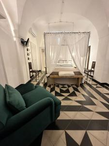 孔韦尔萨诺Masseria Montepaolo Dimora di Charme的客厅配有绿色沙发和床。